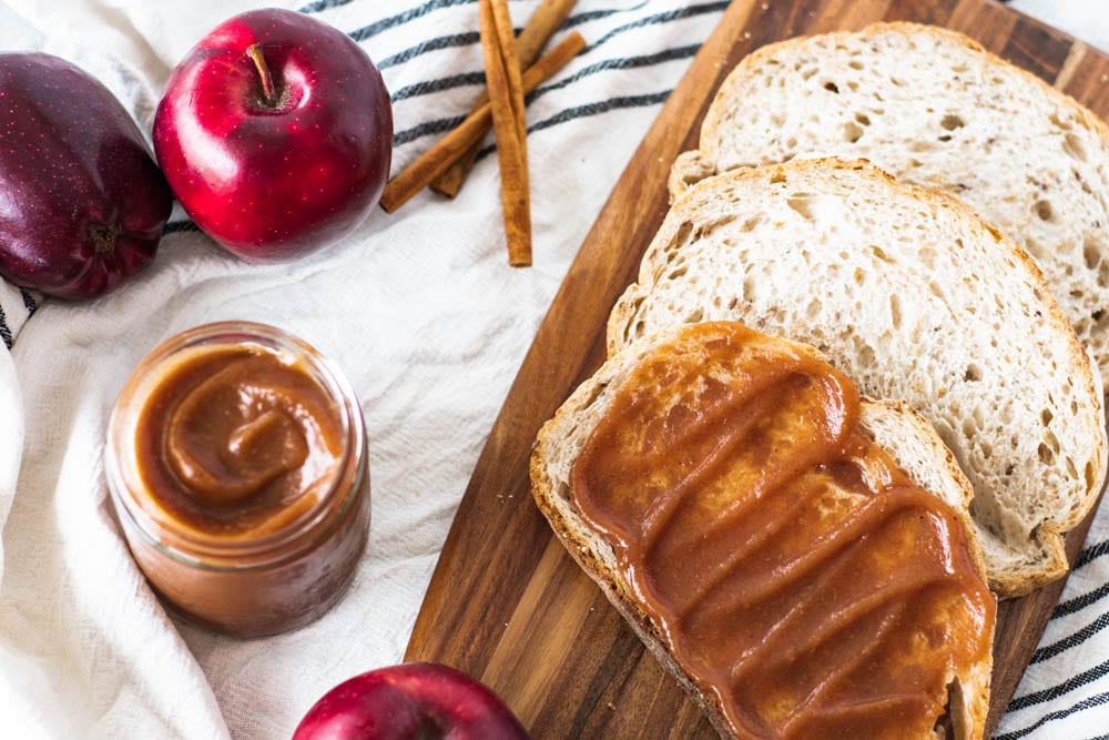 Instant Pot Apple Butter spread on top with cinnamon sticks and apple