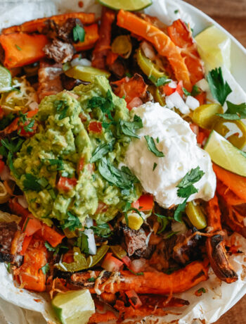 Sweet Potato Carne Asada Fries in a bowl with guacamole and sour cream