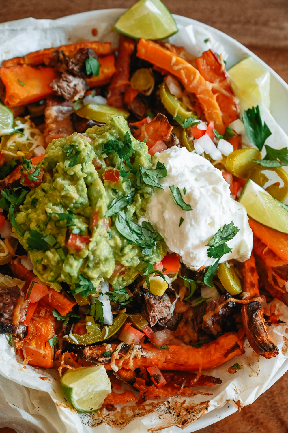 Sweet Potato Carne Asada Fries in a bowl with guacamole and sour cream